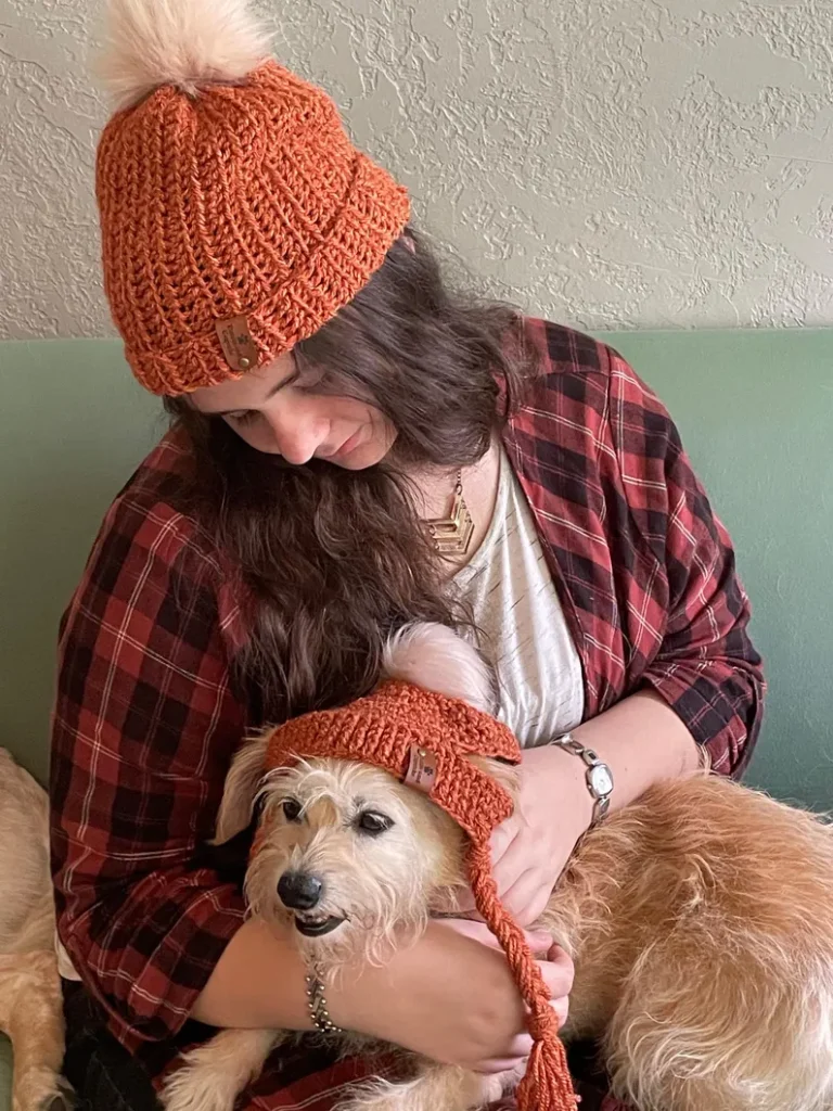 woman and dog wearing matching beanies