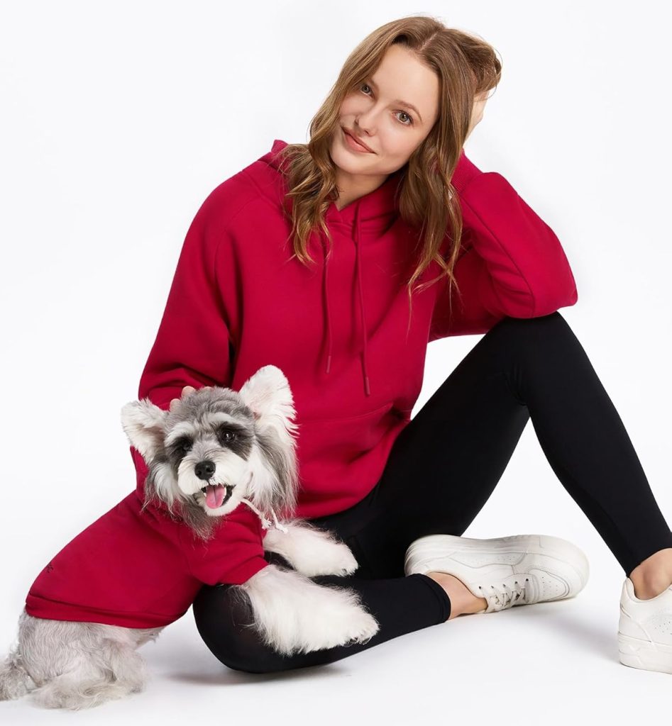 woman and dog wearing red hoodies