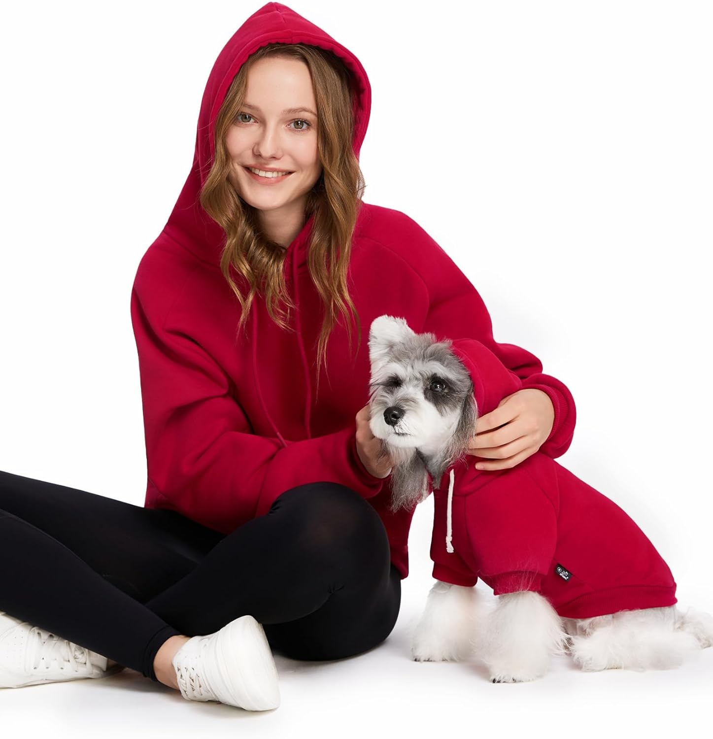 woman and dog wearing red hoodies