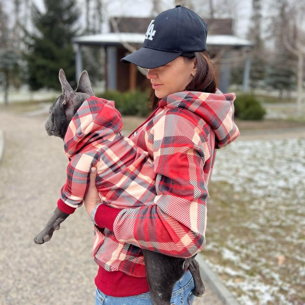 dog and owner wearing red plaid hoodies