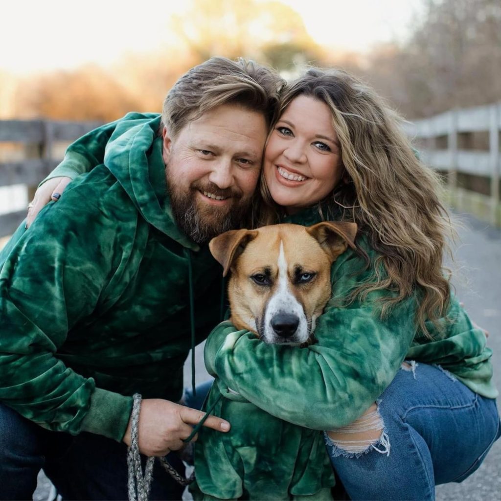 man, woman, dog wearing matching green hoodies